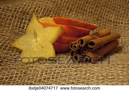 Zimtstangen, Apfelsinenscheiben und Sternfruchtscheiben auf Jute View Large Photo Image Stock Photo - Zimtstangen, Apfelsinenscheiben und Sternfruchtscheiben auf Jute. Fotosearch