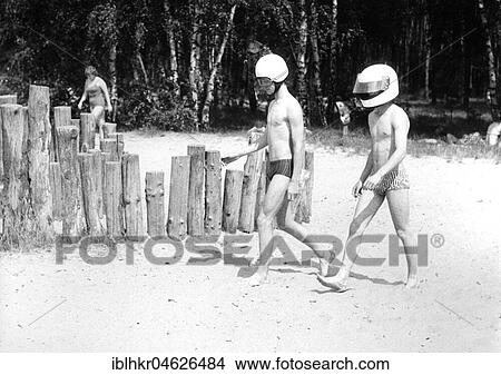 Picture - 2 with motorcycle helmet on the beach, approx. 1980s, Baltic Sea, GDR, Germany, Europe. Fotosearch