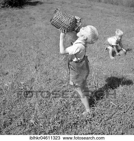 A boy drinks from a wooden vessel, ca. 1955, near Freiburg, Germany, Europe View Large Photo Image Stock Image - A boy drinks from a wooden vessel, ca. 1955, near Freiburg, Germany, Europe. Fotosearch