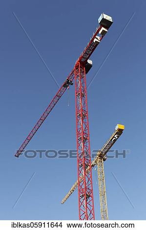 A red and a yellow construction crane in front of a blue sky, Germany, Europe View Large Photo Image Picture - A red and a yellow construction crane in front of a blue sky, Germany, Europe. Fotosearch
