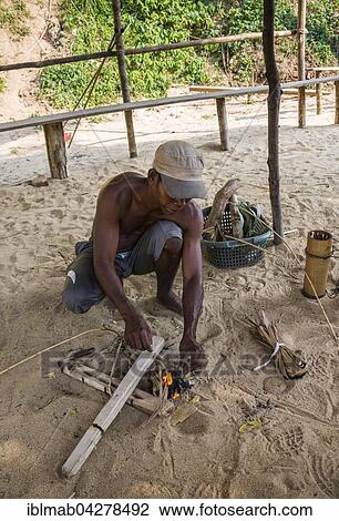 Stock Image - Aboriginal Orang Asil man, making fire, Taman Negara, Malaysia, Asia. Fotosearch