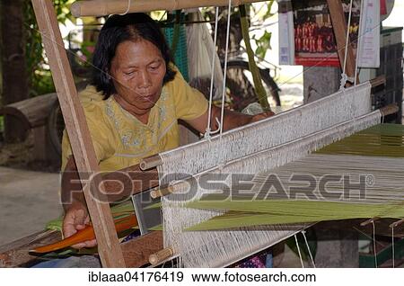 An elderly Tai Dam woman working on an old wooden loom, Loei province, Thailand, Asia View Large Photo Image Stock Photo - An elderly Tai Dam woman working on an old wooden loom, Loei province, Thailand, Asia. Fotosearch