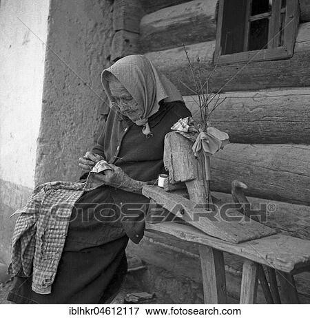 An elderly woman is sitting on a bench and knitting a shirt, ca. 1945 to 1955, Freiburg, Germany, Europe View Large Photo Image Stock Photo - An elderly woman is sitting on a bench and knitting a shirt, ca. 1945 to 1955, Freiburg, Germany, Europe. Fotosearch