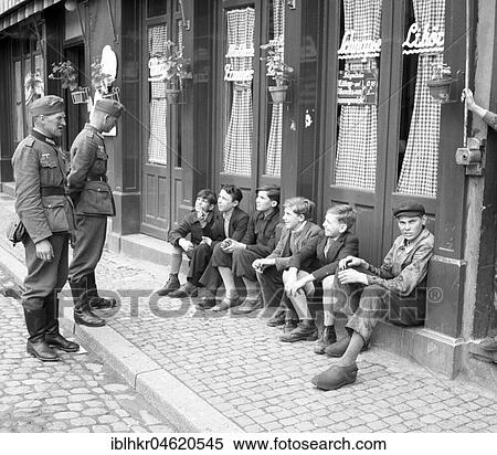 Approx. 1939, 1941, training Wehrmacht, two soldiers talking to boys sitting on the curb, Ulm, Germany, Europe View Large Photo Image Stock Photography - Approx. 1939, 1941, training Wehrmacht, two soldiers talking to boys sitting on the curb, Ulm, Germany, Europe. Fotosearch