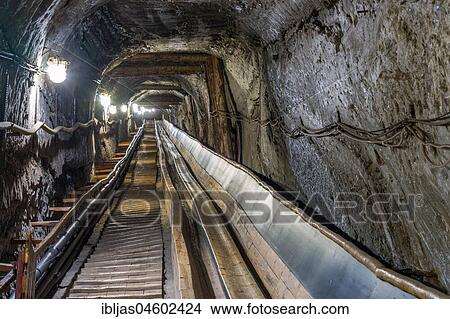 Picture - Belt conveyot in illuminated underground tunnel in salt mine, Bochnia, Poland, Europe. Fotosearch