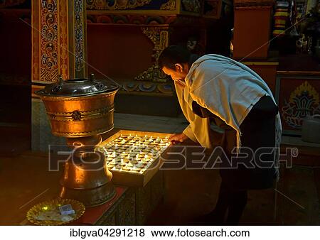 Stock Photo - Bhutanese man at the ceremony of the 1000 butter lamps in a Buddhist monastery, Trashichhoe Dzong, Thimphu, Bhutan, Asia. Fotosearch