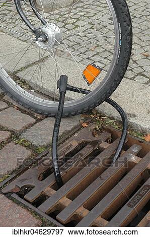 Bicycle attached to the manhole, bicycle lock, Berlin, Germany, Europe View Large Photo Image Stock Photo - Bicycle attached to the manhole, bicycle lock, Berlin, Germany, Europe. Fotosearch
