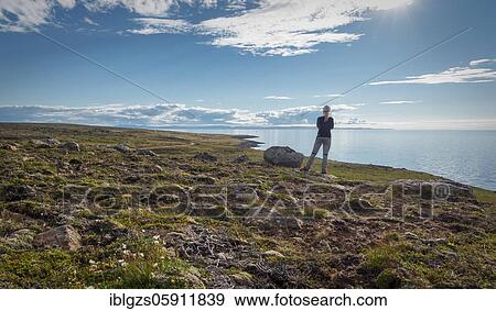 Blonde woman from behind with stands on coast behind sea, Norðurland eystra, Iceland, Europe View Large Photo Image Stock Photo - Blonde woman from behind with stands on coast behind sea, Norðurland eystra, Iceland, Europe. Fotosearch