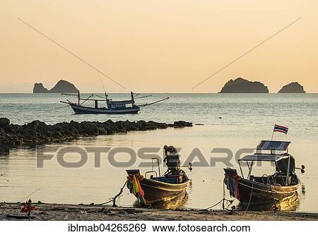 Stock Photo - Boats on the beach in the sea at sunset, small islands in the distance, Koh Samui, Gulf of Thailand, Thailand, Asia. Fotosearch