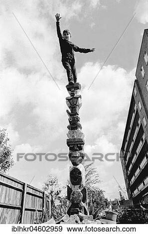 Stock Photo - Boy climbs on pole, England, Great Britain. Fotosearch