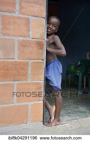 Stock Photograph - Boy in a door, afro-columbian village of El Salto on the River Rio Andagueda, Choco Department, Colombia, South America. Fotosearch