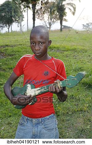 Stock Image - Boy playing on a home-built guitar, Matamba-Solo, Bandundu Province, Congo-Brazzaville, Africa. Fotosearch