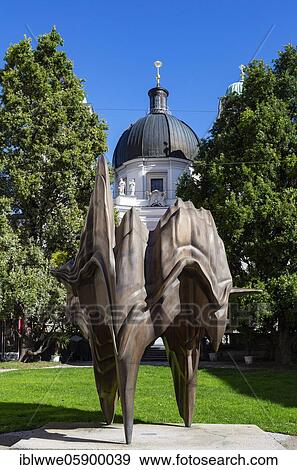 Stock Photo - Bronze statue Caldera at Makartplatz with Trinity Church, Salzburg, Austria, Europe. Fotosearch