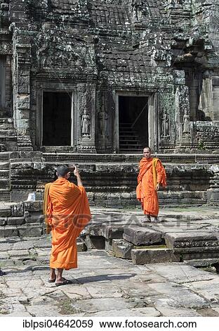 Buddhist monks take pictures with smartphone, Bayon Temple, Angkor Thom, Cambodia, Asia View Large Photo Image Stock Photo - Buddhist monks take pictures with smartphone, Bayon Temple, Angkor Thom, Cambodia, Asia. Fotosearch
