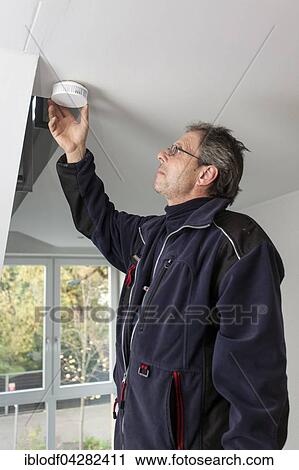 Caretaker with smoke detector in a stairwell, Dusseldorf, North Rhine-Westphalia, Germany, Europe View Large Photo Image Stock Image - Caretaker with smoke detector in a stairwell, Dusseldorf, North Rhine-Westphalia, Germany, Europe. Fotosearch