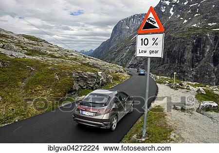 Cars by a warning sign in front of a steep slope, on the mountain road Trollstigen, More og Romsdal, Western Norway, Norway, Europe View Large Photo Image Picture - Cars by a warning sign in front of a steep slope, on the mountain road Trollstigen, More og Romsdal, Western Norway, Norway, Europe. Fotosearch
