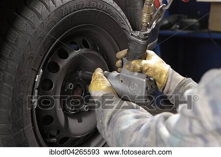 Stock Image - Changing car tires in the workshop, summer tires, winter tires, Germany, Europe. Fotosearch