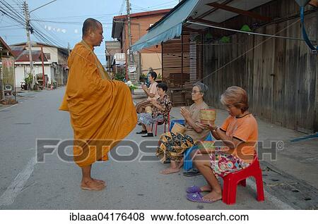 Chiang Khan women offer alms to a monk, Loei province, Thailand, Asia View Large Photo Image Stock Photo - Chiang Khan women offer alms to a monk, Loei province, Thailand, Asia. Fotosearch