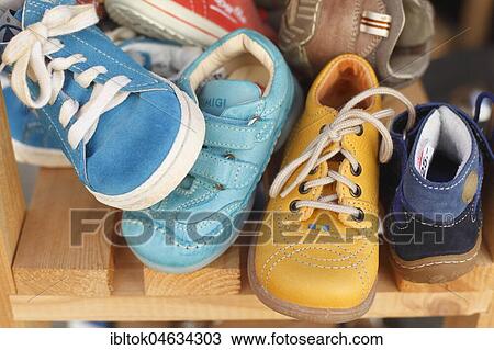 Stock Image - Children's shoes in a shelf, Germany, Europe. Fotosearch
