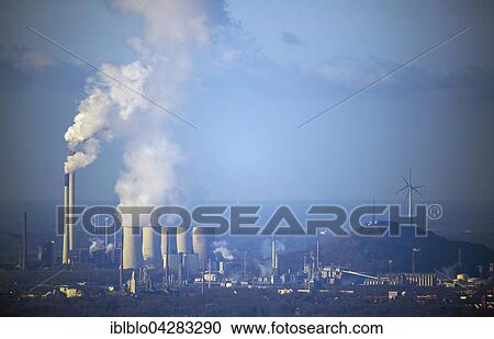 Stock Image - Coal power plant Scholven, cooling towers and heap in haze with wind power plant, Gelsenkirchen, Ruhr district, North Rhine-Westphalia, Germany, Europe. Fotosearch