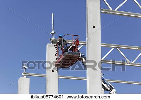 Construction worker on working platform, assembling the roof construction of a logistics hall, Duisburg, North Rhine-Westphalia, Germany, Europe View Large Photo Image Stock Image - Construction worker on working platform, assembling the roof construction of a logistics hall, Duisburg, North Rhine-Westphalia, Germany, Europe. Fotosearch