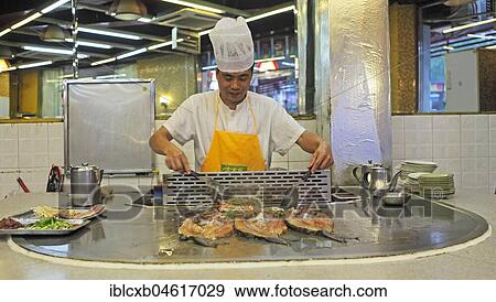 Stock Photo - Cook in a cooking kitchen, preparation of fish, Chengdu, Sichuan, China, Asia. Fotosearch