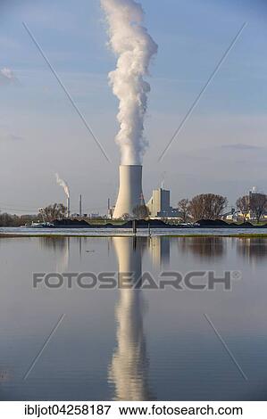 Stock Photo - Cooling tower of the Duisburg Walsum coal power plant, reflection in the flooded Rheinwiese, ship transporting coal, Duisburg, North Rhine-Westphalia, Germany, Europe. Fotosearch