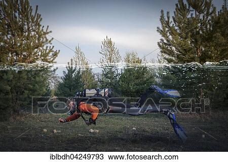 Stock Image - Diver swimming through the forest, composite picture. Fotosearch