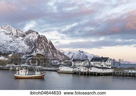 Stock Image - Fishing boat in the harbour at dawn, Hamnøy, Reine, Lofoten, Norway, Europe. Fotosearch