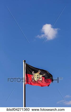 Stock Image - Flag, Kingdom of Wurttemberg, against blue sky with a small cloud. Fotosearch