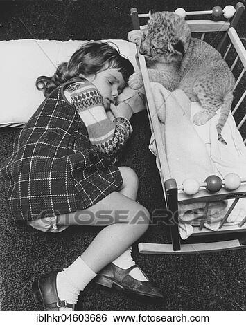 Stock Photograph - Girl sleeping next to a baby predator, England, Great Britain. Fotosearch