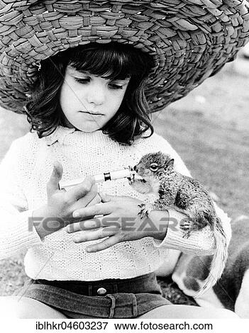 Girl with straw hat feeding chipmunks, England, Great Britain View Large Photo Image Stock Photo - Girl with straw hat feeding chipmunks, England, Great Britain. Fotosearch