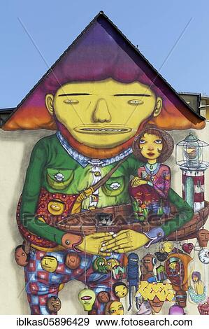 Stock Photo - Happy giant in a play suit, surreal figure, mural of the Brazilian streetart artist duo Os Gemeos, Düsseldorf, North Rhine-Westphalia, Germany, Europe. Fotosearch