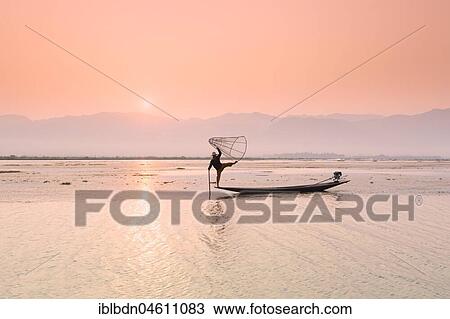 Inle lake fisherman standing on a longtail boat in the distinctive leg rowing stance used by the Intha people, Inle lake, Myanmar, Asia View Large Photo Image Stock Image - Inle lake fisherman standing on a longtail boat in the distinctive leg rowing stance used by the Intha people, Inle lake, Myanmar, Asia. Fotosearch
