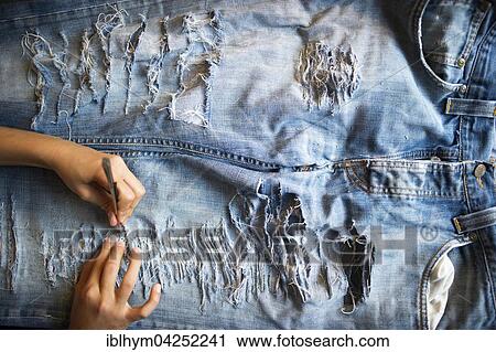 Jeans being torn, holes in the trousers, fashion, Germany, Europe View Large Photo Image Stock Image - Jeans being torn, holes in the trousers, fashion, Germany, Europe. Fotosearch