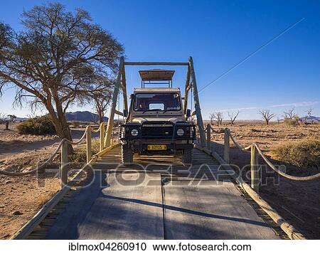 Land Rover crossing a wooden bridge in the Kulala Wilderness Reserve on the edge of the Namib Desert, Hardap Region, Namibia, Africa View Large Photo Image Stock Image - Land Rover crossing a wooden bridge in the Kulala Wilderness Reserve on the edge of the Namib Desert, Hardap Region, Namibia, Africa. Fotosearch