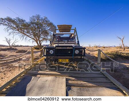 Land Rover crossing a wooden bridge in the Kulala Wilderness Reserve on the edge of the Namib Desert, Hardap Region, Namibia, Africa View Large Photo Image Stock Image - Land Rover crossing a wooden bridge in the Kulala Wilderness Reserve on the edge of the Namib Desert, Hardap Region, Namibia, Africa. Fotosearch
