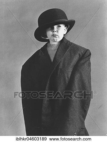 Stock Photo - Little boy in large coat and hat, England, Great Britain. Fotosearch