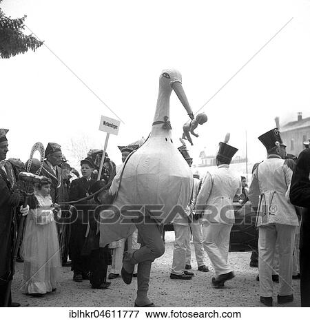 Man dressed as a stork with a baby doll in his beak, carnival, around 1950, Freiburg, Germany, Europe View Large Photo Image Stock Photo - Man dressed as a stork with a baby doll in his beak, carnival, around 1950, Freiburg, Germany, Europe. Fotosearch