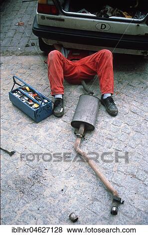 Stock Photo - Man repairs car, car literature, Berlin, Germany, Europe. Fotosearch