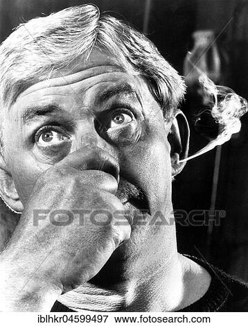 Stock Photo - Man smokes through ear, England, Great Britain. Fotosearch