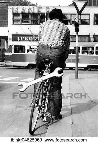 Stock Photo - Man with huge wrench on bicycle ca. 1970s, exact place unknown, Czech Republic, Europe. Fotosearch
