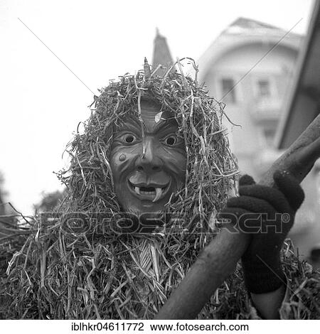 Stock Image - Masked man with pointed teeth and a suit made of straw, carnival, around 1950, Freiburg, Germany, Europe. Fotosearch