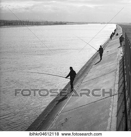 Men standing on the banks of a river and fishing, ca. 1945 to 1955, near Freiburg, Germany, Europe View Large Photo Image Stock Photo - Men standing on the banks of a river and fishing, ca. 1945 to 1955, near Freiburg, Germany, Europe. Fotosearch