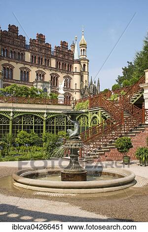 Stock Image - Muschelbrunnen, clam fountain, in Muschelbrunnenhof, large hall of the orangery behind, Schwerin Palace, Schwerin, Mecklenburg-Western Pomerania, Germany, Europe. Fotosearch