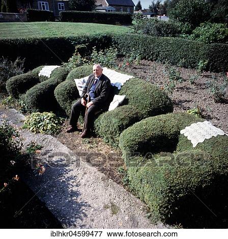 Old man sitting on an armchair cut from a hedge, England, Great Britain View Large Photo Image Stock Photo - Old man sitting on an armchair cut from a hedge, England, Great Britain. Fotosearch