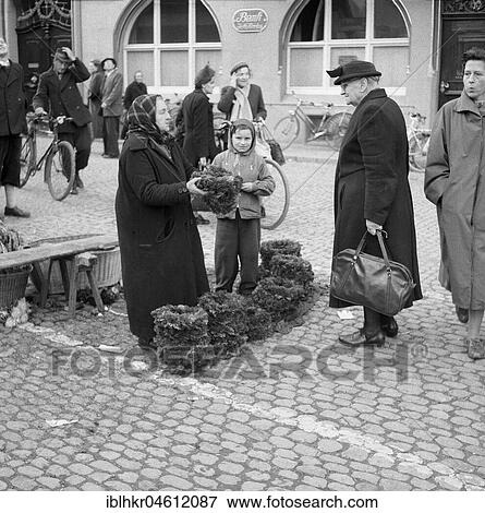Older woman and boy sell flower wreaths, Freiburger Münstermarkt, approx. 1945 to 1955, Freiburg, Germany, Europe View Large Photo Image Stock Photo - Older woman and boy sell flower wreaths, Freiburger Münstermarkt, approx. 1945 to 1955, Freiburg, Germany, Europe. Fotosearch