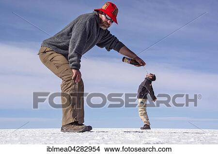 Optical illusion, man pouring beer into small man's mouth, Salar de Uyuni, Bolivia mouth View Large Photo Image Picture - Optical illusion, man pouring beer into small man's mouth, Salar de Uyuni, Bolivia mouth. Fotosearch