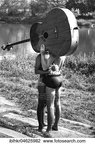 Pair behind big guitar ca. 1970s, exact place unknown, Czech Republic, Europe View Large Photo Image Stock Image - Pair behind big guitar ca. 1970s, exact place unknown, Czech Republic, Europe. Fotosearch