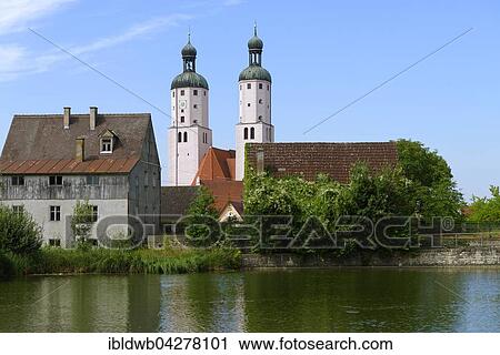 Stock Image - Parish Church of St. Emmeram with the city pond, Wemding, Swabia, Bavaria, Upper Bavaria, Germany, Europe. Fotosearch